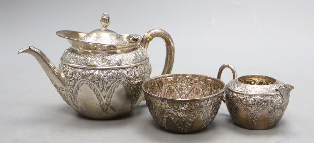 A late Victorian bachelors embossed silver three piece tea set, Mappin & Webb, Sheffield, 1895, gross 16 oz.